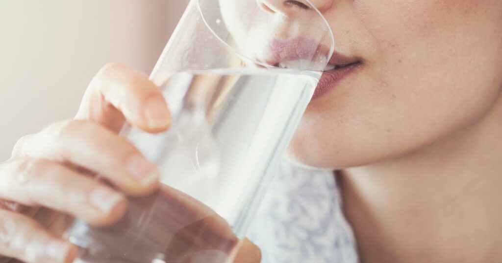 Woman drinking water containing Sunfiber soluble fiber