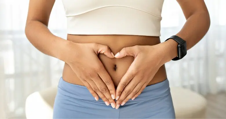 Woman with hands in heart shape over stomach