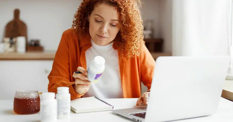 Woman reading nutrition labels sitting at desk